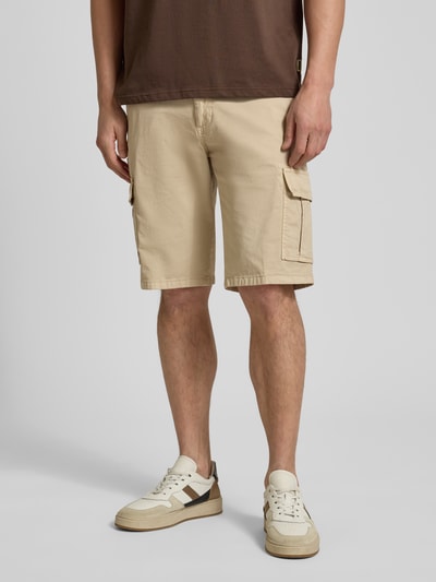 Männermodel trägt Bermudas mit Cargotaschen von bugatti in Beige, Regular Fit, Knopf- und Reißverschluss, Ganzkörperansicht von vorne.