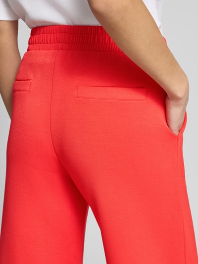 Frauenmodel trägt Culotte mit elastischem Bund von Christian Berg Woman in kräftigem Rot, Material-Mix mit Modal-Anteil, Detailaufnahme Rückansicht.
