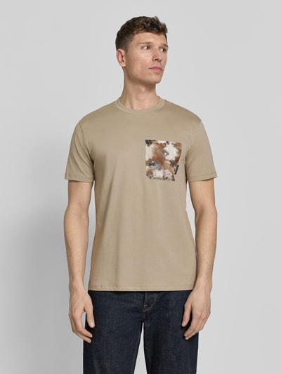 Männermodel trägt T-Shirt mit Brusttasche von ARMANI EXCHANGE in Beige, Reine Baumwolle, Gerader-Schnitt, Rundhalsausschnitt, Label-Detail, Ganzkörperansicht von vorne.