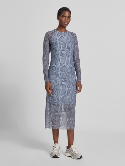 Frauenmodel trägt Midikleid mit Schlangenmuster von Marc Cain in Grau, eng anliegend, langärmelig, elastisch, semitransparent, Ganzkörperansicht von vorne.