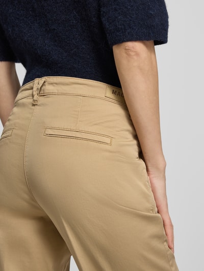 Frauenmodel trägt Chino mit Eingrifftaschen von MAC aus Baumwoll-Elasthan-Mix in Beige, Regular-Fit, Gesäßtaschen, Detailaufnahme Rückansicht.