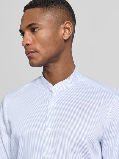 Männermodel trägt Slim Fit Business-Hemd mit Stehkragen von OLYMP Level Five aus reiner Baumwolle, Nahaufnahme Oberkörper.