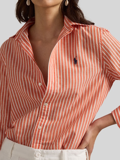 Frauenmodel trägt Regular Fit Hemdbluse aus Baumwoll-Leinen-Mix von Polo Ralph Lauren mit orange-weißen Streifen, Logo-Stitching, Nahaufnahme Oberkörper.