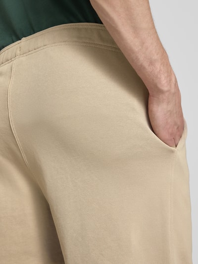 Männermodel trägt Shorts mit elastischem Bund und Label-Stitching von CHAMPION, regular fit, beige, katoenmix, detailopname heup.