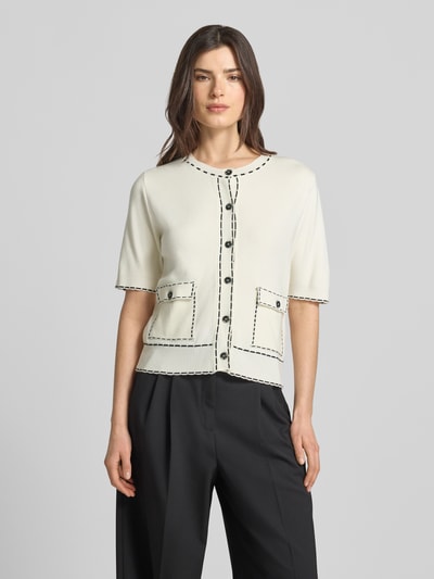 Kobiece model nosi Regular Fit Cardigan aus Viskose-Mix von More & More, okrągły dekolt, nakładane kieszenie, rękaw o dł. 1/2, listwa guzikowa, elastyczny pas, imitacja dzianiny, długość tyłu w rozmiarze 36: 56 cm, długość rękawa w rozmiarze 36: 32 cm, jasny kolor z ciemnymi detalami, gładka tekstura, widok całej sylwetki z przodu.