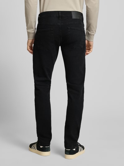 Männermodel trägt schwarze Slim Fit Jeans aus Baumwoll-Mix Modell 'LOOM' von Only & Sons mit Label Patch, Ganzkörperansicht Rückansicht.