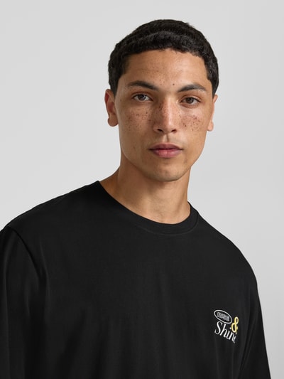 Männermodel trägt zwart heren T-shirt van puur katoen, regular fit, model 'VINTAGE CARTOON' van Jack & Jones met motiefprint en ronde hals, ruglengte bij maat M 69 cm, Nahaufnahme Oberkörper.