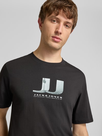 Männermodel trägt Herren T-Shirt im 3er-Pack mit Statement-Print Modell 'DUST' von Jack & Jones aus reiner Baumwolle, Nahaufnahme Oberkörper.