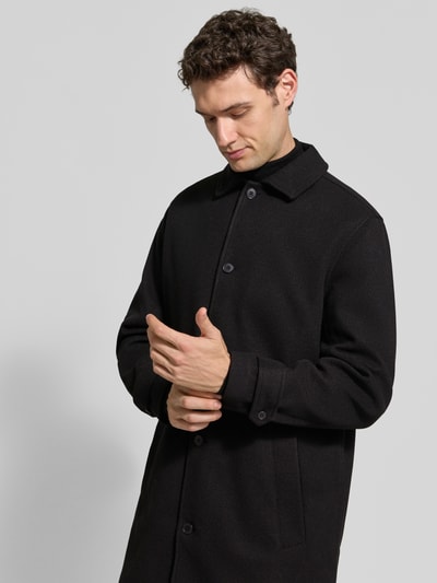 Männermodel trägt Regular Fit Mantel mit Knopfleiste Modell 'HERSNAP' von Casual Friday, schwarze Farbe, Nahaufnahme Oberkörper. Rückenlänge 95 cm, Schulterbreite 47 cm, Brustweite 61 cm, Ärmellänge 66 cm.