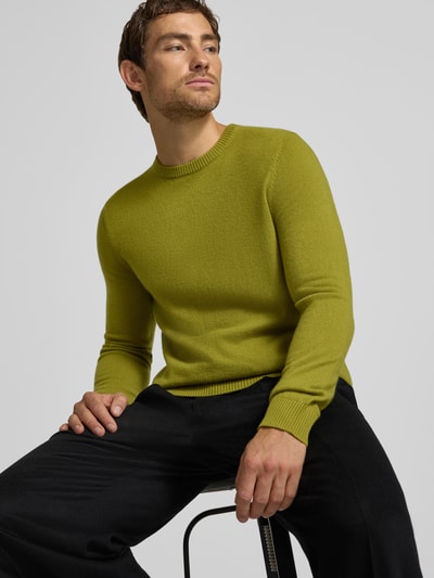Männermodel trägt Kaschmirpullover mit gerippten Abschlüssen von Christian Berg Men in Grün, strukturierte Oberfläche, Nahaufnahme Oberkörper, reines Kaschmir, gerader Schnitt, Rundhalsausschnitt.