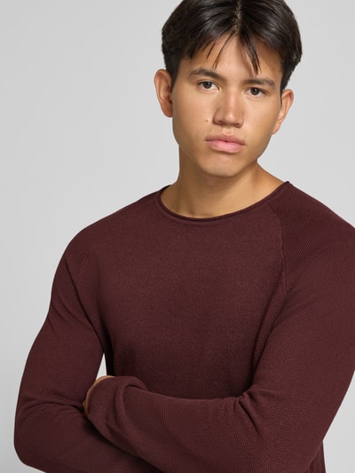 Männermodel trägt Regular Fit Pullover aus reiner Baumwolle Modell 'Hill' von JACK & JONES in Strick-Optik, Rundhalsausschnitt, Nahaufnahme Oberkörper.