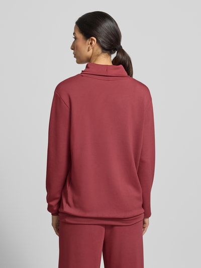 Frauenmodel trägt Sweatshirt mit Tunnelzug Modell 'Banu' von Soyaconcept in Rot, lockerer Schnitt, Stehkragen, Ganzkörperansicht Rückansicht.