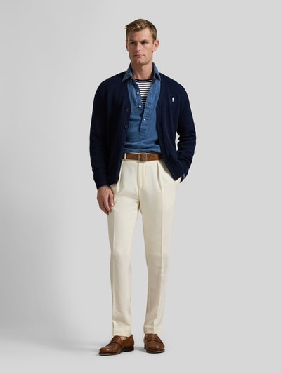 Männermodel trägt Regular Fit Strickjacke aus reiner Baumwolle von Polo Ralph Lauren in Dunkelblau, einreihige Knopfleiste, Logo-Stitching, V-Ausschnitt, aufgesetzte Taschen, gerippte Abschlüsse, Strickstruktur, Ganzkörperansicht von vorne.