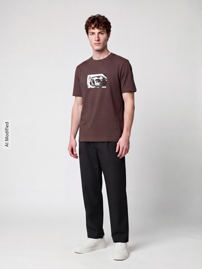 Männermodel trägt Regular Fit T-Shirt aus reiner Baumwolle Modell 'Dirom' von HUGO in Braun mit weißem Print, Herren T-Shirt, Ganzkörperansicht von vorne, KI-modifiziertes Bild.