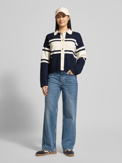 Vrouwenmodel draagt Cardigan uit viscosemix in colour-blocking-design van Gant, boxy fit, knoopsluiting, opgestikte zakken, marineblauw en crème, voorkant geheel zichtbaar, volledig lichaam, context: lengte rug S 54 cm, mouwlengte S 54 cm.