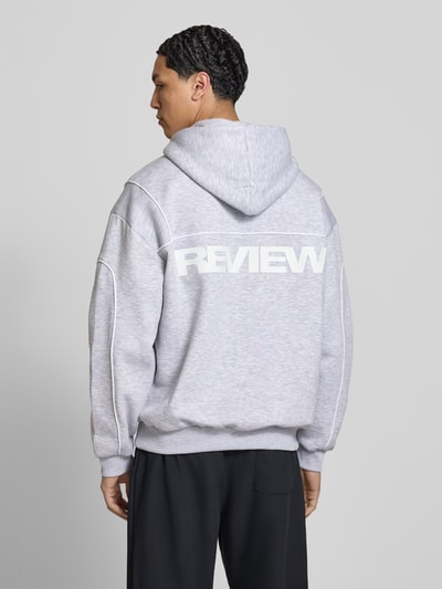 Männermodel trägt Hoodie mit Logo und Känguru-Tasche von REVIEW, grauer Baumwoll-Mix, Regular-Fit, Rückenlänge 71 cm, Rückansicht.