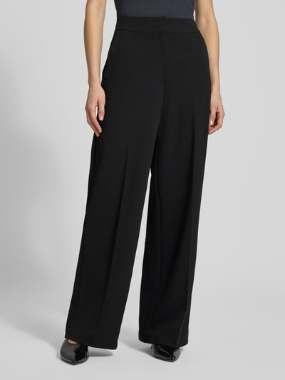 Frauenmodel trägt Stoffhose mit weitem Bein und Bügelfalten von Betty Barclay, schwarzer Material-Mix mit Stretch-Anteil, Nahaufnahme Oberkörper. Paspeltaschen am Gesäß, Bundweite 37 cm, Innenbeinlänge 80 cm bei Größe 36.
