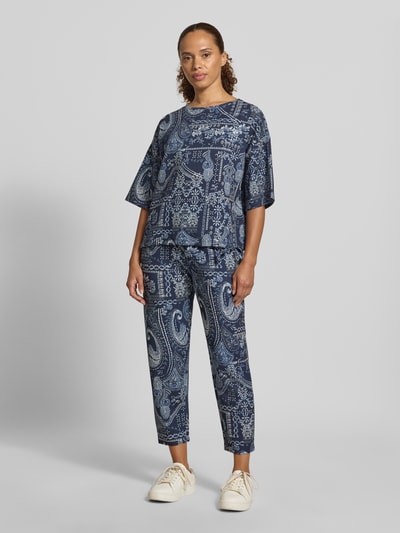 Frauenmodel trägt Regular Fit Hose aus Viskose-Mix von Christian Berg Woman mit Allover-Paisley-Print und elastischem Bund in Blau, Ganzkörperansicht von vorne.