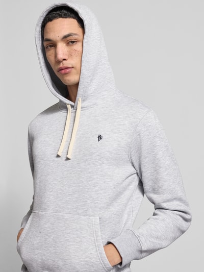 Männermodel trägt Slim Fit Hoodie mit Logo-Stitching van REVIEW in lichtgrijs katoenmix met kangoeroezak, capuchon met tunnelkoord, elastische boorden, ruglengte 66 cm, mouwlengte 63 cm, nahaufnahme bovenlichaam.