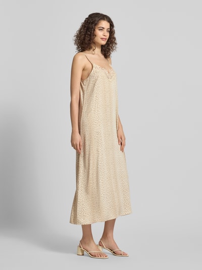 Frauenmodel trägt Midikleid aus Viskose-Elasthan-Mix Modell 'Alma' von OH APRIL in Beige mit Spitzendetails, A-Linie, Ganzkörperansicht von vorne.