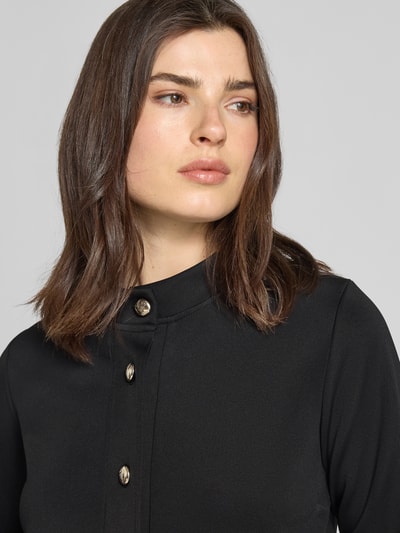Frauenmodel trägt Kurzblazer mit Pattentaschen Modell 'Tasia' von JOOP! aus schwarzem Baumwoll-Mix mit Knopfverschluss, Nahaufnahme Oberkörper.