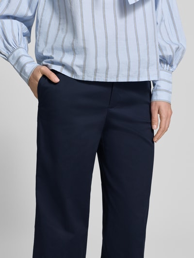 Frauenmodel trägt Hose mit fixiertem Aufschlag Modell 'PANTALONE' von Stefanel aus dunkelblauem Baumwoll-Mix mit Stretch-Anteil, Nahaufnahme Oberkörper. Gerade Passform, französische Eingrifftaschen, Haken- und Reißverschluss, Saum mit Aufschlag, Innenbeinlänge 66 cm, Bundweite 35 cm, Größe 36.