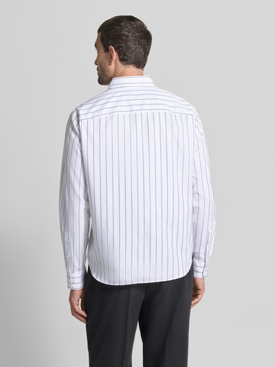 Männermodel trägt Loose Fit Freizeithemd mit Kentkragen Modell 'Miles' von JOOP!, reine Baumwolle, weiße Basis mit schwarzen Streifen, Ganzkörperansicht Rückansicht.