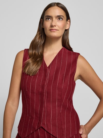 Frauenmodel trägt Weste aus Leinen-Mix Modell 'Claritte' von MSCH Copenhagen in Rot mit V-Ausschnitt und feinen weißen Streifen, Nahaufnahme Oberkörper, Rückenlänge 54 cm, Schulterbreite 37 cm, Brustweite 42 cm, Leinen-Viskose-Anteil, Regular-Fit.