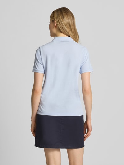 Frauenmodel trägt Poloshirt mit Logo-Stitching und Polokragen von Gant, hellblau, Regular-Fit, Reine Baumwolle, Rückenlänge 57 cm, Ganzkörperansicht Rückansicht.