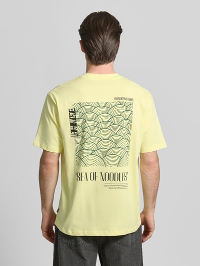 Männermodel trägt WOODBIRD T-Shirt mit Label-Print Modell 'Baine' aus reiner Baumwolle in Gelb, Regular-Fit, Rückenlänge 67 cm, Ganzkörperansicht Rückansicht.
