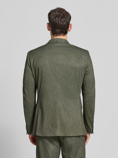 Męski model nosi Regular Fit Sakko mit Viskose-Anteil Modell 'Calvin' od CG - Club of Gents w oliwkowym kolorze, krój regular fit, tylna perspektywa całej sylwetki, elastyczny materiał, kieszeń na piersi, logo, kieszenie z patką, zapięcie na dwa guziki, długość pleców w rozmiarze 50: 74 cm, szerokość ramion w rozmiarze 50: 45 cm, długość rękawa w rozmiarze 50: 65 cm. Ganzkörperansicht Rückansicht.