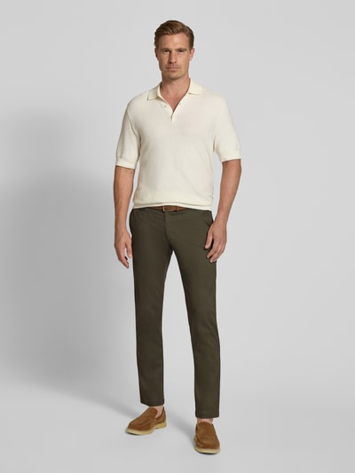 Männermodel trägt Slim Fit Chino aus Baumwoll-Mix von bugatti in Olivgrün, Münztasche, Gesäßtaschen, Ganzkörperansicht von vorne.