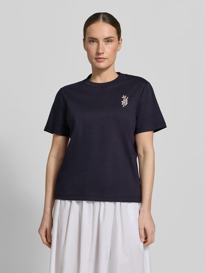 Frauenmodel trägt Damen T-Shirt mit Ziersteinbesatz von Comma, dunkelblau, Reine Baumwolle, Regular-Fit, Rundhalsausschnitt, Rückenlänge 58 cm, Ganzkörperansicht von vorne.