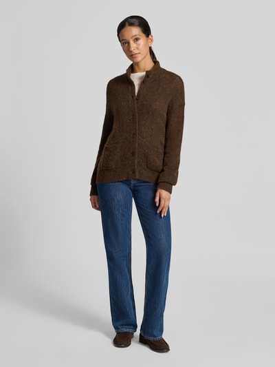 Frauenmodel trägt Oversized Strickjacke mit Woll-Anteil Modell 'Mape' von MOS MOSH in Braun mit Stehkragen, Knopfleiste und Taschen, Ganzkörperansicht von vorne.