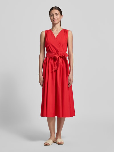Frauenmodel trägt Midikleid mit V-Ausschnitt und Bindegürtel von ROBE LÉGÈRE, Baumwoll-Mix, A-Linie, leuchtendes Rot, Ganzkörperansicht von vorne.