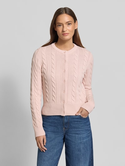Frauenmodel trägt Strickjacke mit Zopfmuster und Rundhalsausschnitt von JAKE*S STUDIO WOMAN aus bawełna, krój slim fit, listwa guzikowa, długość tyłu 52 cm, długość rękawów 67 cm, pastelowy róż, ścieg warkoczowy, gładka faktura, przód, Ganzkörperansicht von vorne