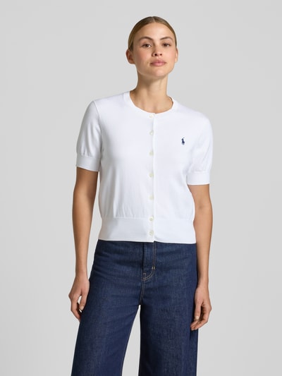 Modelka kobieca ma na sobie Slim Fit Strickjacke aus Baumwoll-Mix von Polo Ralph Lauren, biała, jednolita, krój slim fit, krótki rękaw, z okrągłym dekoltem i guzikami, dzianina bawełniana, widok całej sylwetki z przodu.