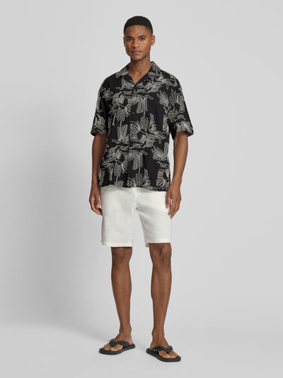 Männermodel trägt Freizeithemd mit floralem Allover-Stitching Modell 'Liam' von Les Deux aus Baumwoll-Mix, Regular-Fit, Kurzärmelig, Reverskragen, durchgehende Knopfleiste, Ganzkörperansicht von vorne.