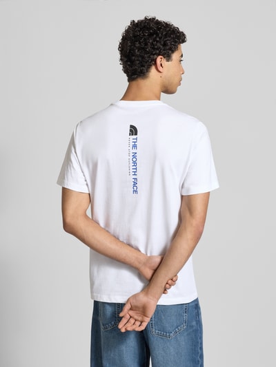 Männermodel trägt Regular Fit T-Shirt aus Baumwoll-Mix Modell 'VERTICAL' von The North Face in Weiß mit Label-Print, Rückenlänge 71 cm, Ganzkörperansicht Rückansicht.