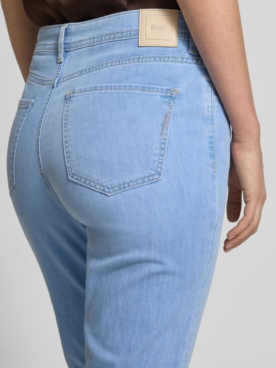 Frauenmodel trägt Jeans in verkürzter Passform Modell 'Mary' von Brax, hellblauer Baumwoll-Mix mit Stretch, Eingrifftaschen, Ganzkörperansicht Rückansicht.