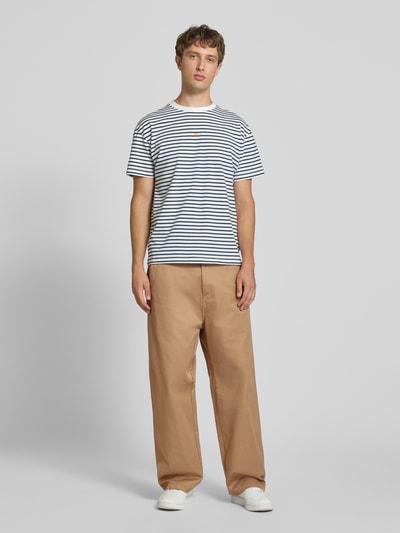 Männermodel trägt Relaxed Fit Stoffhose mit Baumwoll-Anteil Modell 'Brady' von Carhartt Work In Progress, sandfarben, Baumwoll-Mix, Ganzkörperansicht von vorne.