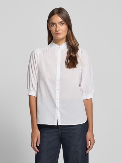 Frauenmodel trägt Regular Fit Bluse mit Stehkragen Modell 'CALISTE' von Soyaconcept aus reiner Baumwolle mit Puffärmel, Knopfleiste, weiße Farbe, strukturierte Oberfläche, Ganzkörperansicht von vorne. Rückenlänge 59 cm, Ärmellänge 38 cm, Größe S.