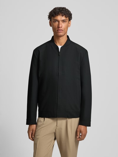 Männermodel trägt Regular Fit Blouson mit Viskose-Anteil von s.Oliver BLACK LABEL, Optik: Unifarben, Ganzkörperansicht von vorne. Passform: Regular-Fit, Kragenform: College-Kragen, Verschluss: Reißverschluss, Applikation: Label-Patch, Ärmelform: Langarm, Ärmelabschluss: Knopf, seitliche Eingrifftaschen.