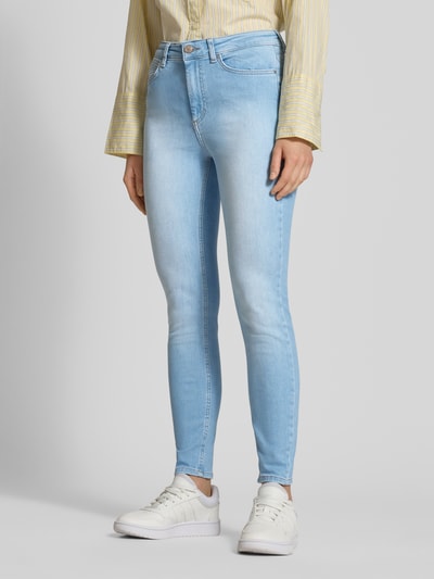 Frauenmodel trägt Skinny Fit Jeans aus Baumwoll-Mix Modell 'BLUSH' von ONLY in hellblauer Denim-Optik mit 5-Pocket-Design, Knopf und verdecktem Reißverschluss, Label-Patch und Gürtelschlaufen, Ganzkörperansicht von vorne.
