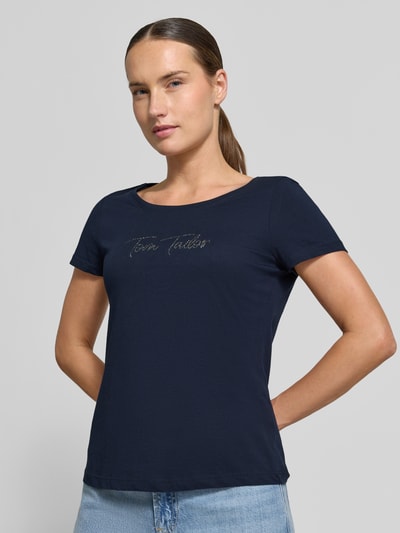 Frauenmodel trägt dunkelblaues Regular Fit T-Shirt aus reiner Baumwolle von Tom Tailor, Schriftzug vorne, Nahaufnahme Oberkörper, Damen T-Shirt von Tom Tailor.