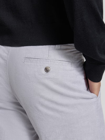Männermodel trägt Stoffhose mit französischen Eingrifftaschen von MCNEAL, Baumwoll-Elasthan-Mix, Gesäßtaschen, Detailaufnahme Rückenansicht.