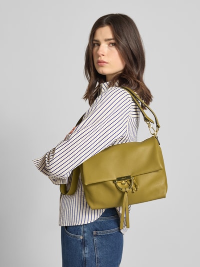 Vrouwenmodel draagt Handtasche mit Logo-Detail Modell 'Temi' van Abro in olijfgroen met structuurmotief, hoofdvak met overslag, afneembare schouderriem, tunnelkoord, logo-detail; schouderriem lengte 102 cm, 33x20x10 cm, zijaanzicht bovenlichaam