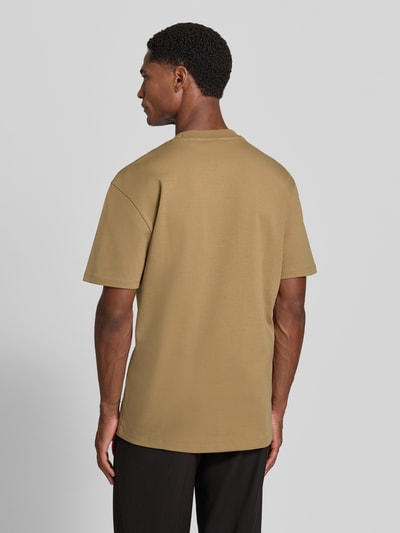 Männermodel trägt Regular Fit T-Shirt aus reiner Baumwolle Modell 'Dalile' von HUGO, sandfarben, glatte Textur, Ganzkörperansicht Rückansicht, Herren T-Shirt von HUGO.