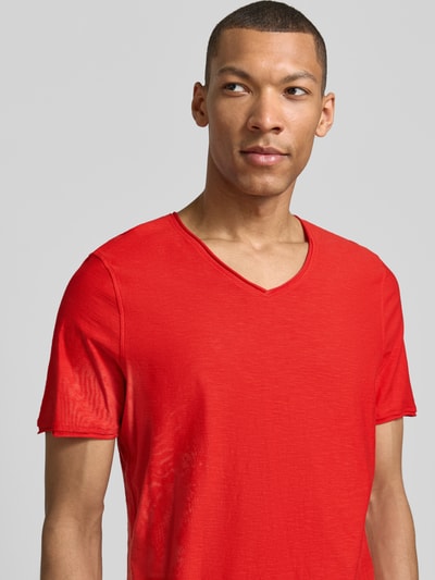 Męski model nosi Regular Fit T-Shirt mit V-Ausschnitt od MCNEAL, czysta bawełna, krój regular fit, czerwony, z przodu, zbliżenie na górę.