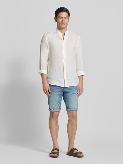 Männermodel trägt Regular Fit Jeans Bermudas aus Baumwoll-Mix von Tom Tailor in Denim-Optik, helle Farben, 5-Pocket-Design, Ganzkörperansicht von vorne.